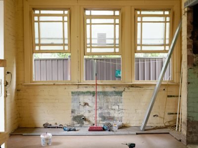 An empty room featuring large windows, ready for renovation in Sydney, Australia.